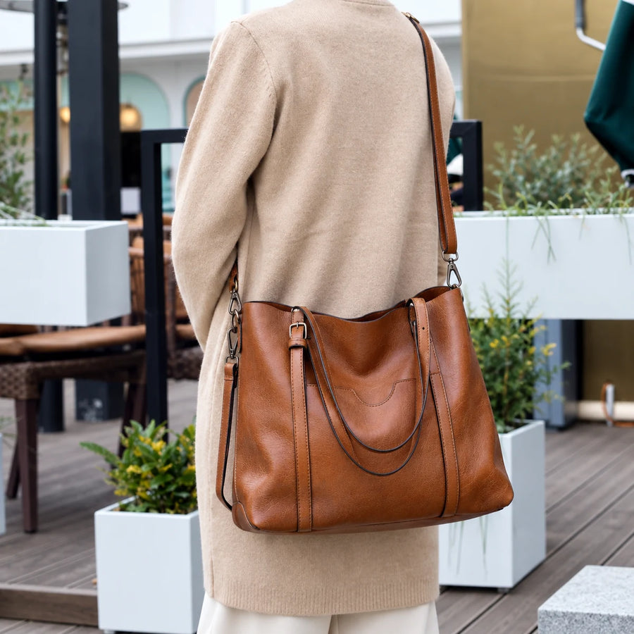 Woman carrying the Eleonora tote on her shoulder on a cafe terrace